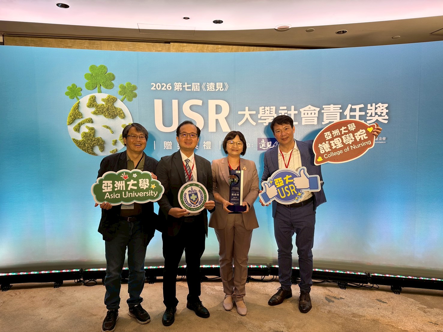 图说：亚洲大学黄俊杰副校长(左二)、护理学院院长吴桦姗(右二)、社工系施睿谊助理教授(左一)，与远见杂志副社长兼智库总编辑李建兴(右一)于2026《远见》USR大学社会责任奖颁奖典礼合影。